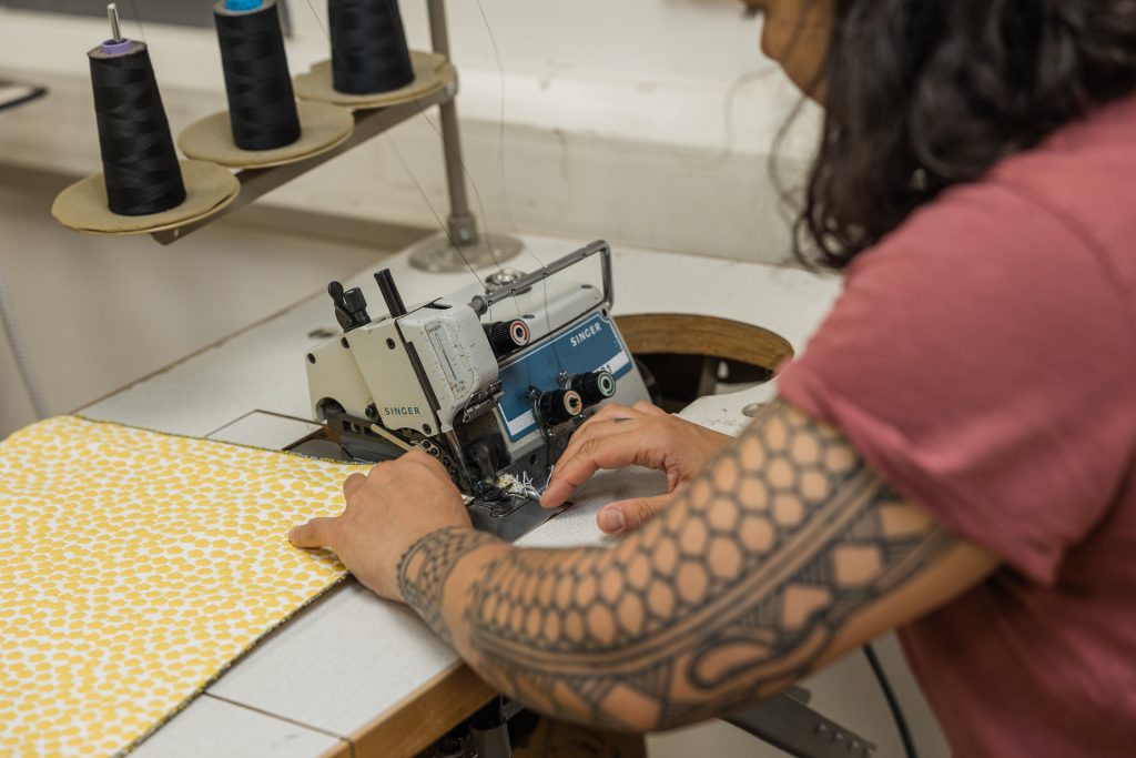 Close up of hands sewing fabric with singer sewing machine